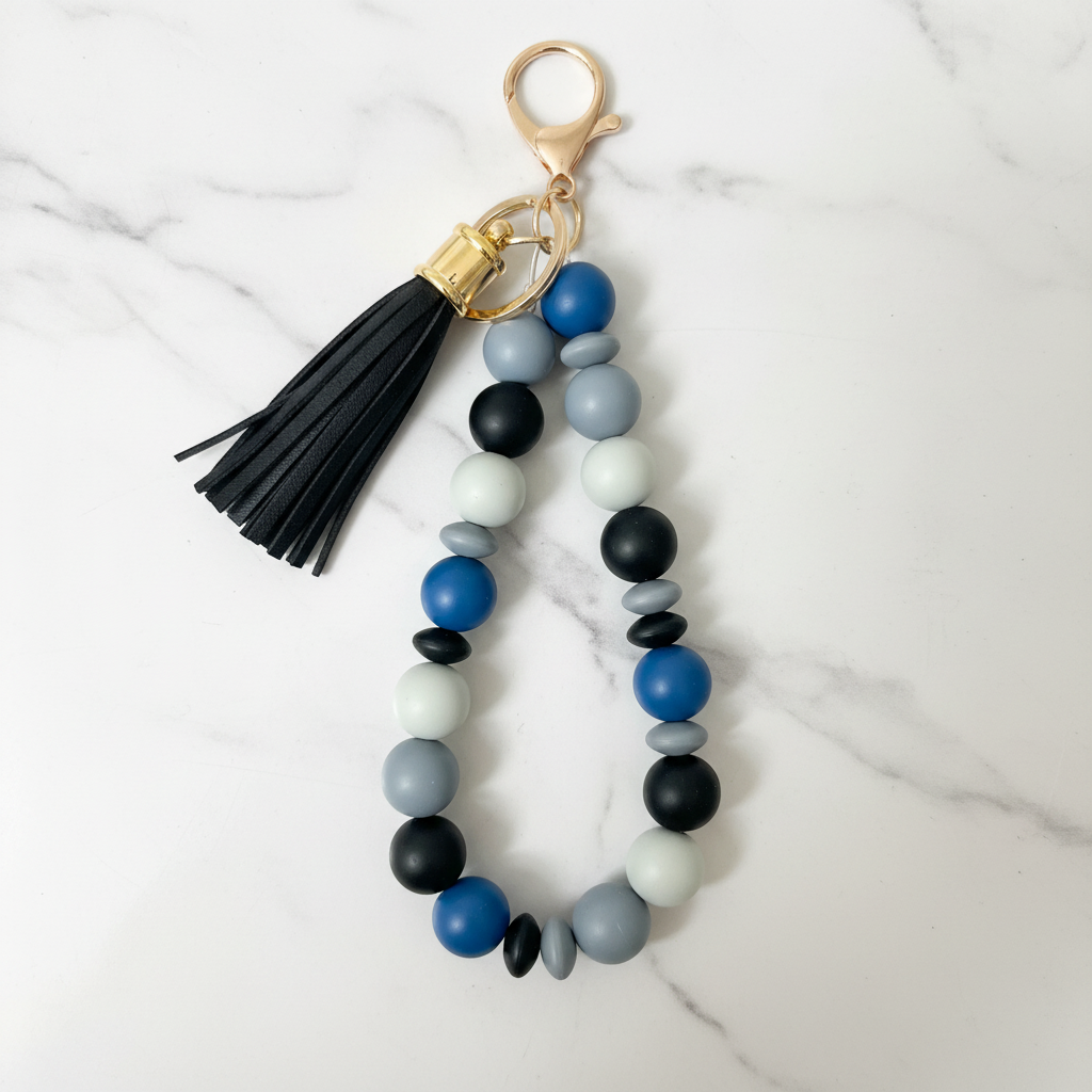 Porte-clés bracelet perles silicone bleu pompon noir - fond marbré vue 3