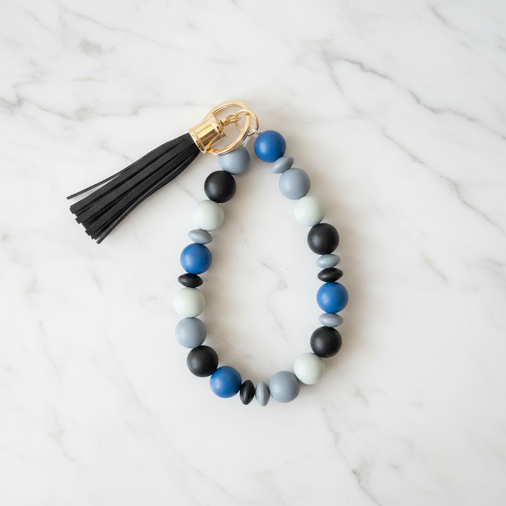 Porte-clés bracelet perles silicone bleu pompon noir - fond marbré vue 2