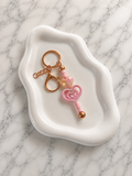 Porte-clés clé magique rose en forme de cœur avec finitions dorées