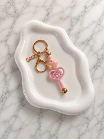 Porte-clés clé magique rose en forme de cœur avec finitions dorées