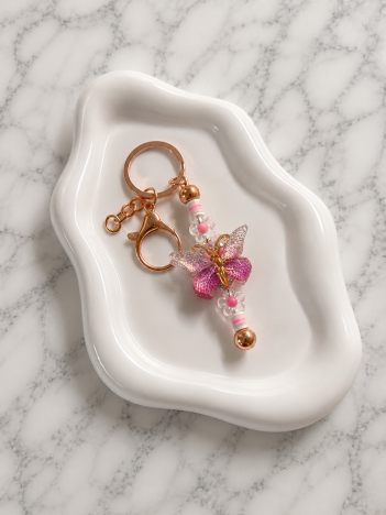 Porte-clés papillon rose aux ailes translucides dorées avec perles