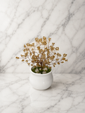 Arbre Doré en Perles Artisanales – perles de rocaille dorées dans un vase en céramique blanche sur fond marbré
