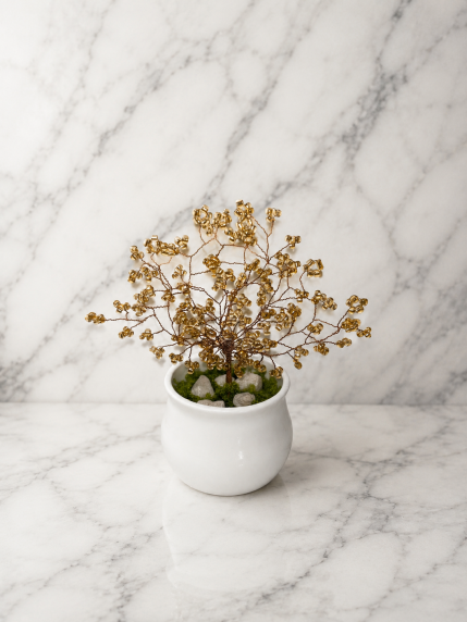 Arbre Doré en Perles Artisanales – perles de rocaille dorées dans un vase en céramique blanche sur fond marbré